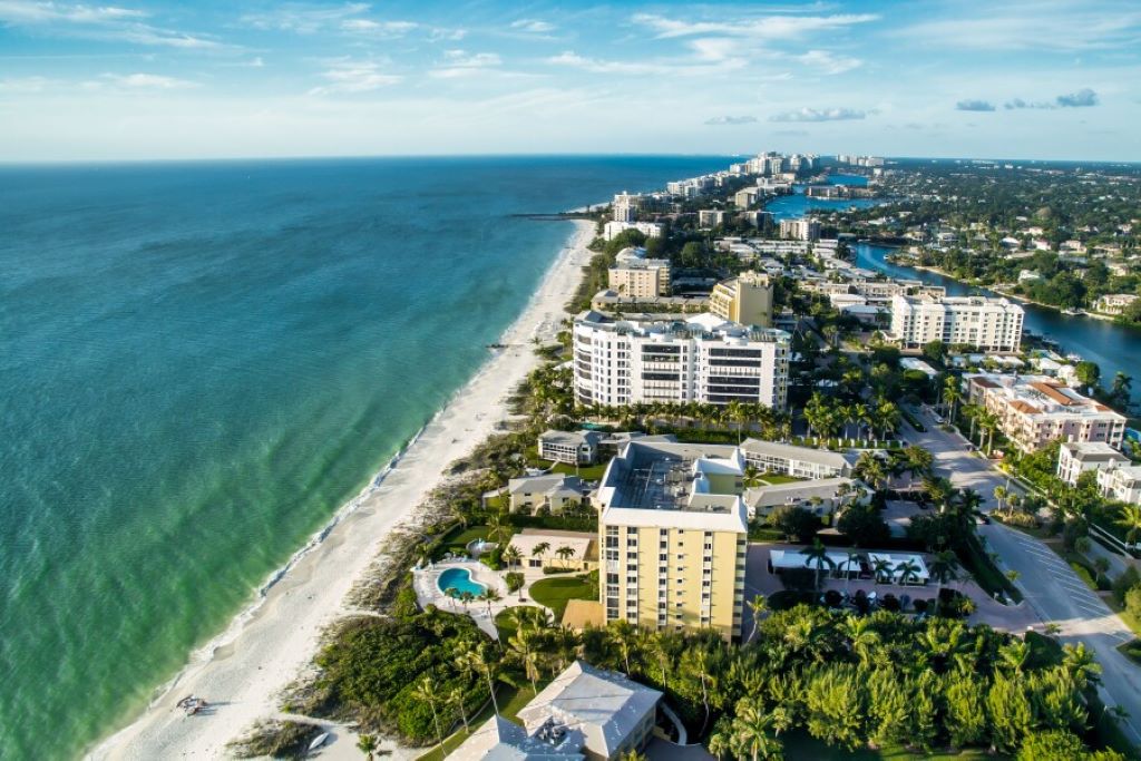 Travel planning scene in Florida for Europe adventure with itinerary notes, suitcase, and destination map.